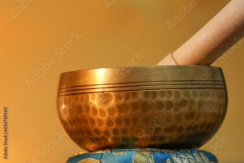 Ornate, hand-hammered Tibetan bell on a golden background photo