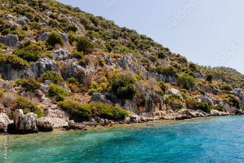 Beautiful view of the Mediterranean Sea with yachts. Picturesque landscape of blue ocean and green mountains on a sunny summer day. The sunken city of Kekova, Türkiye - 28 July 2023