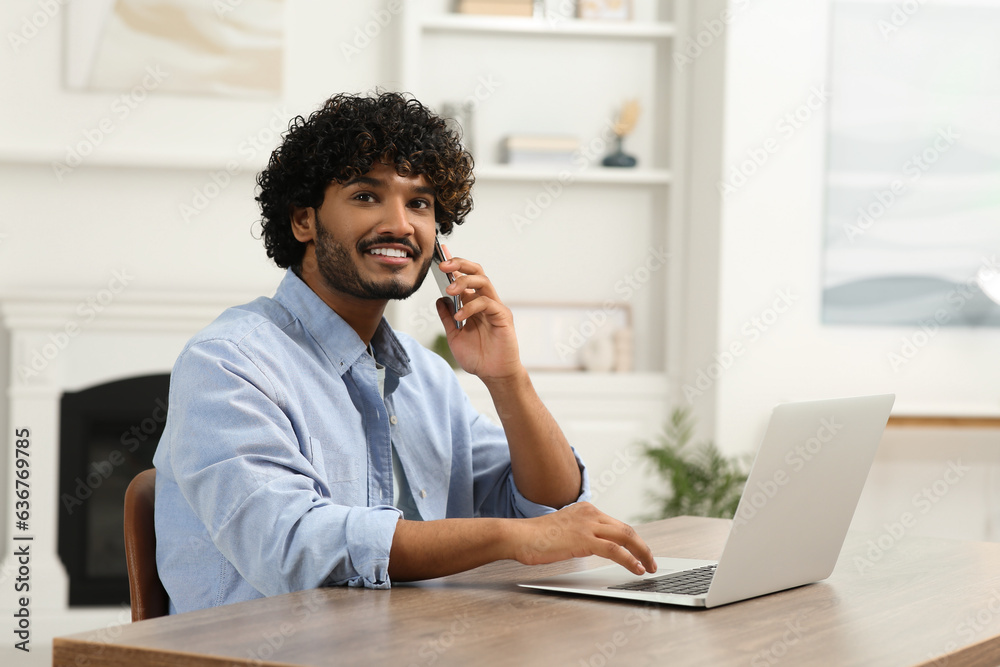 Handsome smiling man talking on smartphone in room, space for text Handsome smiling man talking on smartphone in room, space for text