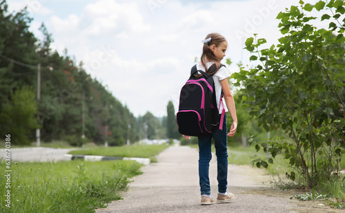 Little girl with backpack going to school  back view. Back to school