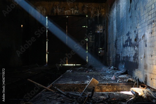 Single sunbeam illuminating the interior of an old abandoned factory.