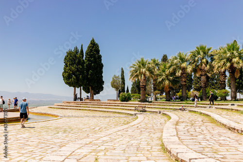 Many tourists visit the beautiful park with ancient architecture in Pamukkale, Türkiye. Mountain landscape. Ancient city of Hierapolis, Pamukkale, Türkiye - July 29, 2023