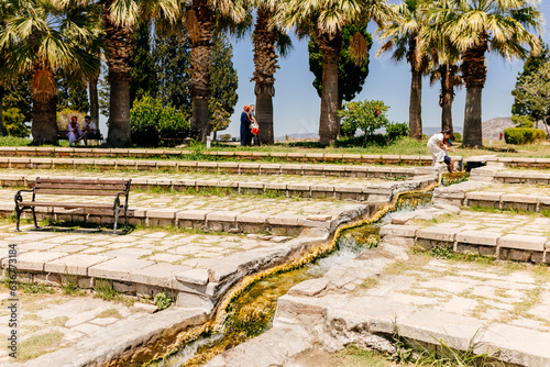 Many tourists visit the beautiful park with ancient architecture in Pamukkale, Türkiye. Mountain landscape. Ancient city of Hierapolis, Pamukkale, Türkiye - July 29, 2023