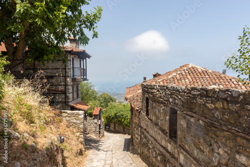 Narrow cobbled street with old stone houses in traditional Greek village Palaios Panteleimonas photo