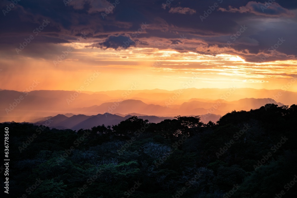 Stunning sunset illuminates the landscape of a misty mountain range.