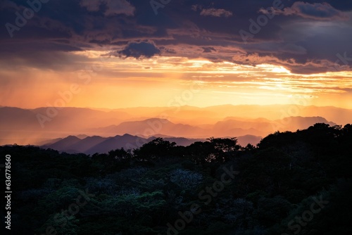 Stunning sunset illuminates the landscape of a misty mountain range.