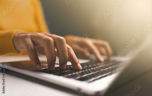 Business woman hands using Laptop typing on keyboard and surfing the internet on office table.