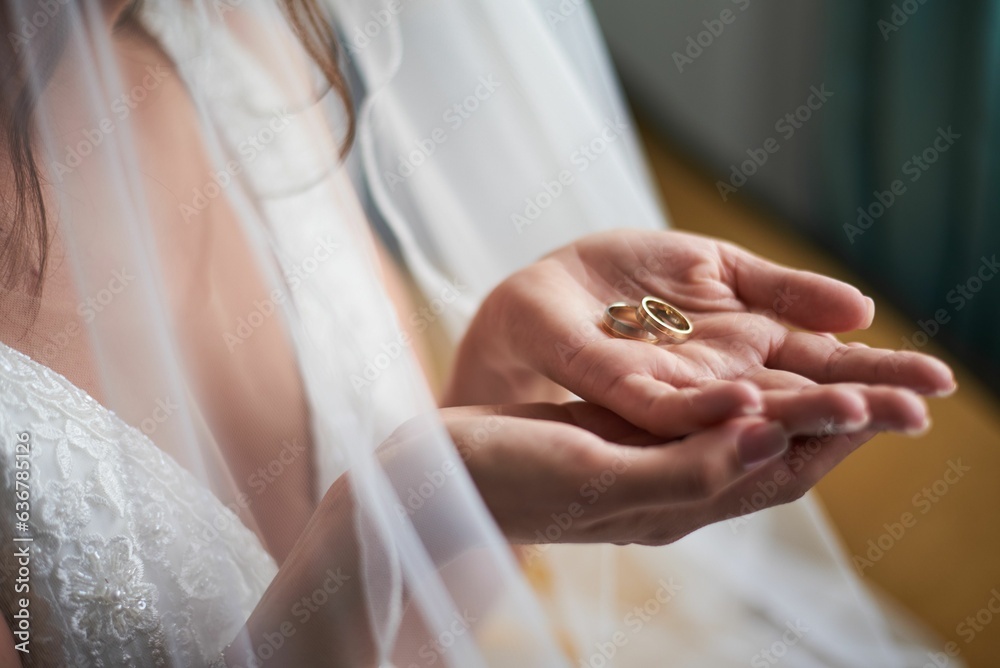 Closeup shot of the bride's hands clasping two gold wedding rings. Closeup shot of the bride's hands clasping two gold wedding rings.