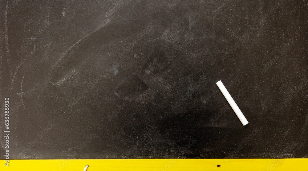Closeup of a black chalkboard with chalks under the natural light Closeup of a black chalkboard with chalks under the natural light