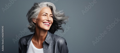 Portrait of a Mature Beautiful Woman Looking Left on a Grey Background with Space for Copy. Haircare, Skincare, Healthy Living