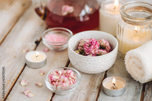 Aromatherapy. Organic natural floral, plant ingredients for spa treatment in salon. Rose petals, essential oil, burning candles, towels, delicious herbal tea, Atmosphere of relax, detention.