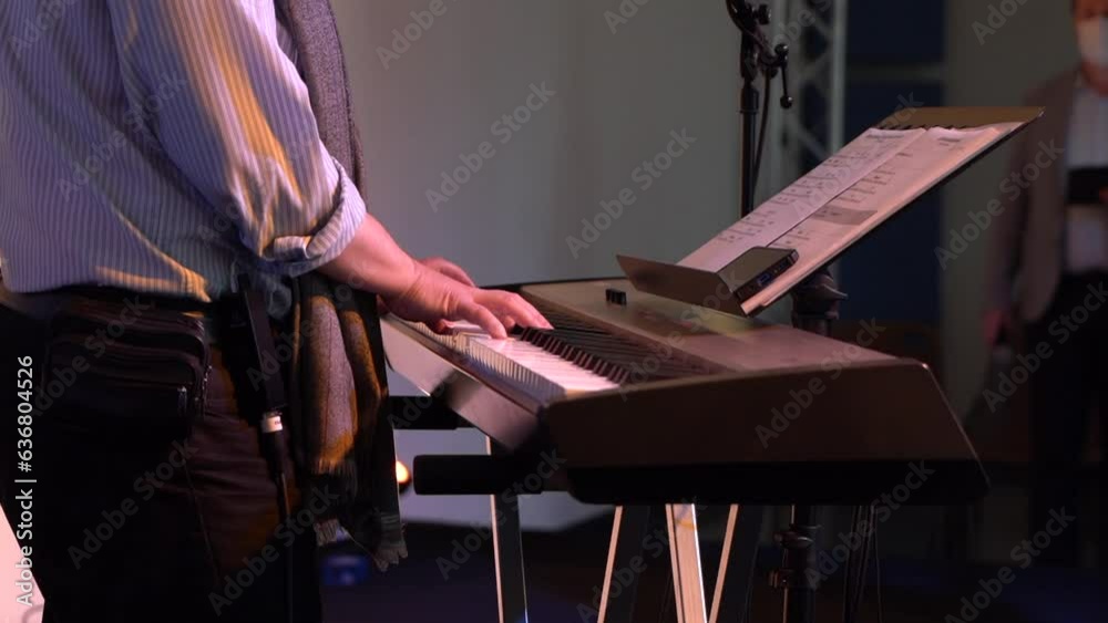 Personne qui joue du clavier électronique débout