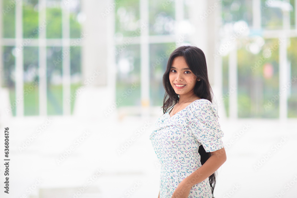 Young Asian woman indoors. Girl at big window.