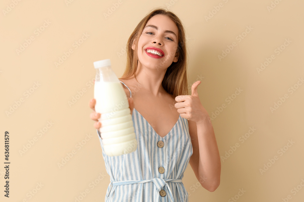 Happy young woman with milk showing thumb-up on beige background Happy young woman with milk showing thumb-up on beige background