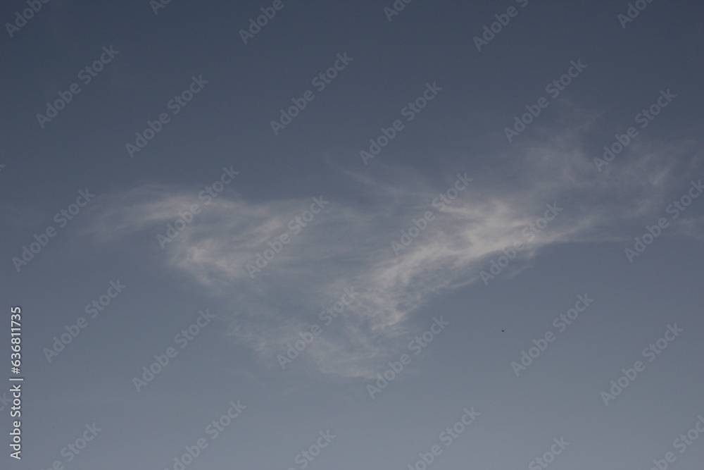 Obraz premium Wispy clouds in the sky, in a swirly, triangular shape