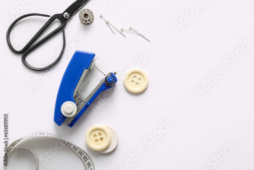 Manual sewing machine with different supplies on white background