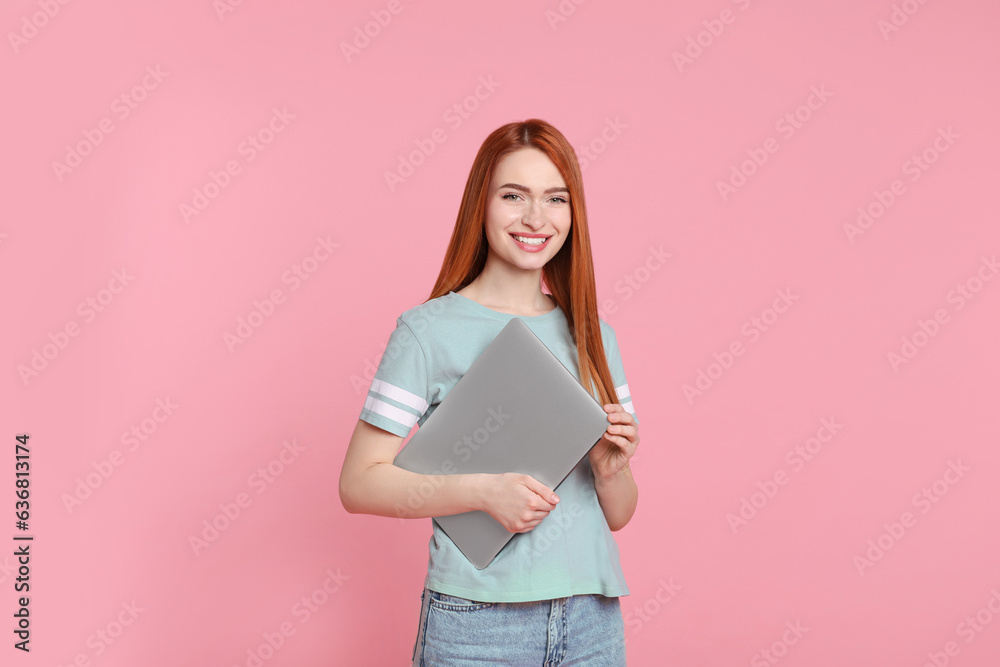 Smiling young woman with laptop on pink background Smiling young woman with laptop on pink background
