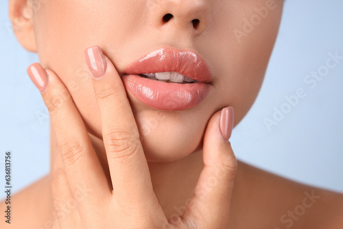 Tableau sur toile Young woman with beautiful lips on blue background, closeup