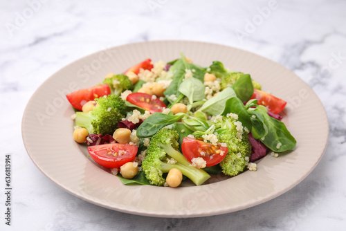Healthy meal. Tasty salad with quinoa, chickpeas and vegetables on white marble table, closeup
