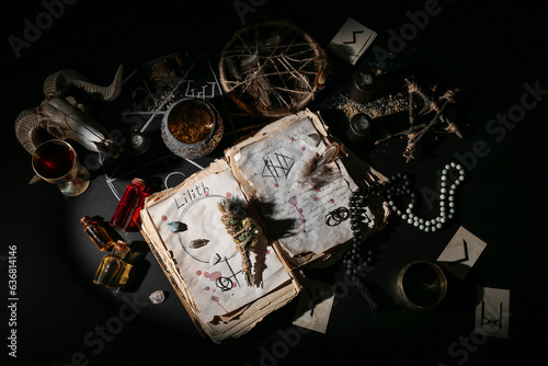 Witch's magic attributes with spell book on dark background