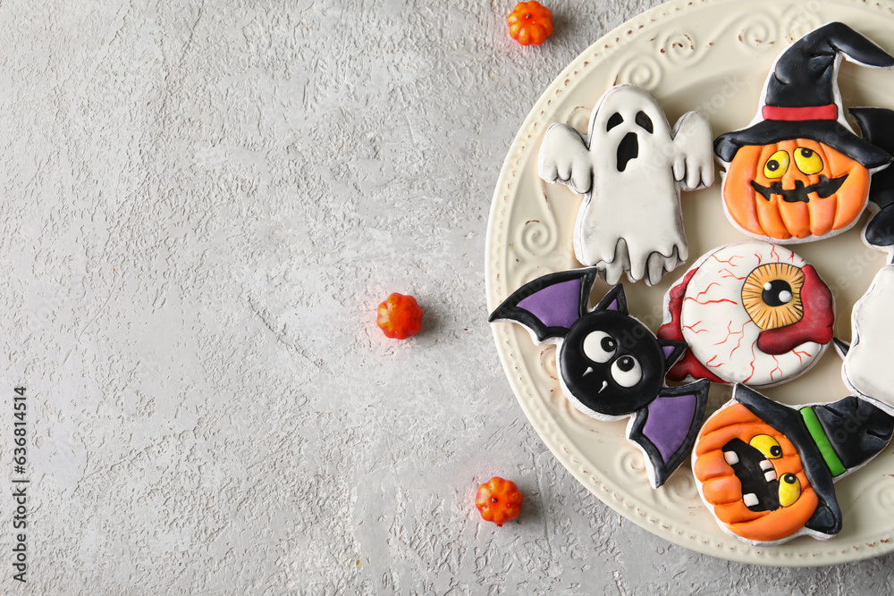 Plate with tasty cookies and pumpkins for Halloween celebration on grey background