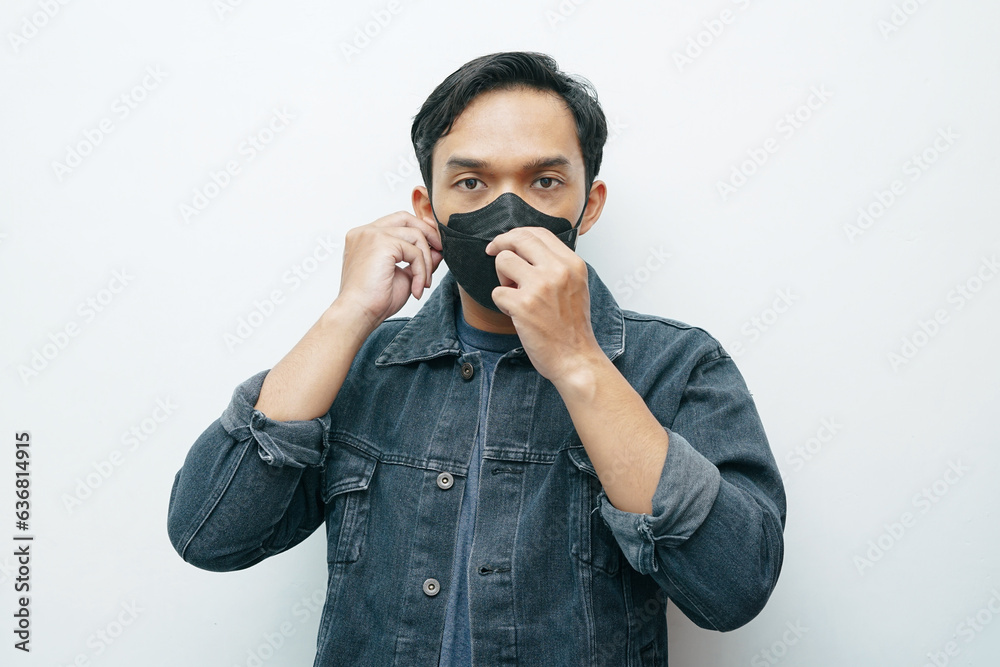 Portrait of an Asian Indonesian man wearing protective mask to prevent infection virus or bad air quality. isolated white background Portrait of an Asian Indonesian man wearing protective mask to prevent infection virus or bad air quality. isolated white background