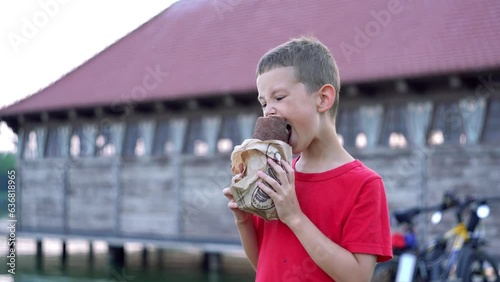Kid eats a hot kürtőskalács (trdelnik), blows on it to cool. 

