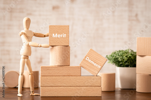 Foto There is wood cube with the word Merit Demerit