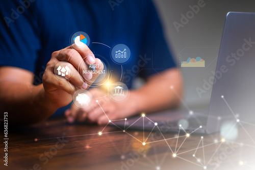 Asset management concept, Man using laptop with word asset management and Icon  on virtual display. Financial Property Digital assets.