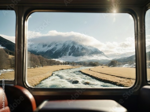 Wanderlust & Travel. Train Window View: A shot taken from inside a train, showing a majestic view of passing landscapes over a river. There is a snowy mountain in the back