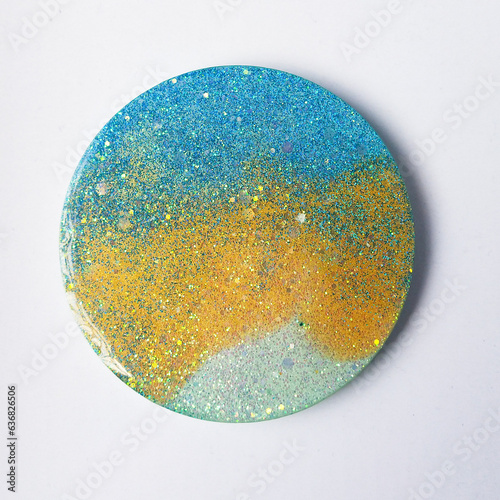 Handmade resin coaster with floral pattern on white background. Selective focus.