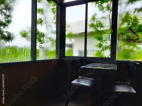 A room with a table and chairs in front of a window