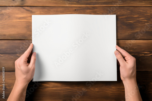 Close-up of hands holding white paper book