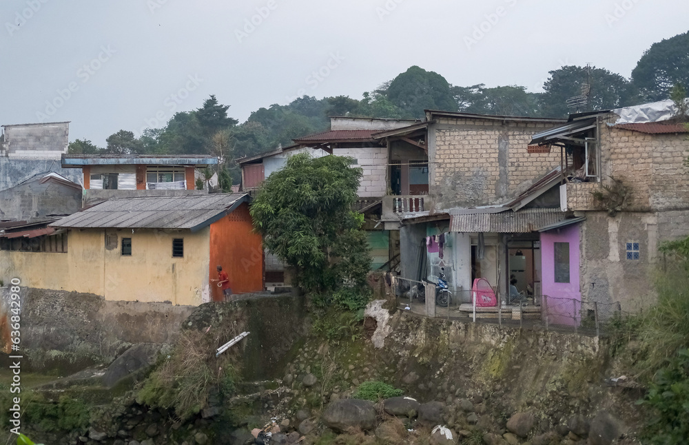 densely populated residential area in the city of Bogor, densely populated area along the river,  ciliwung river, landslide-prone houses in Bogor, river in the village, houses in the village