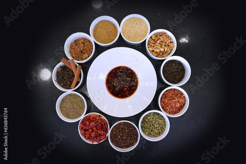 chef signature homemade spices chilli cinnamon pepper curry green leaf dry herb ingredient in bowl for laksa on black marble table asian halal food cuisine menu for restaurant