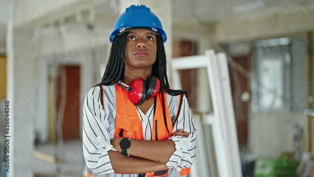 African american woman builder standing with arms crossed gesture and serious expression at construction site African american woman builder standing with arms crossed gesture and serious expression at construction site