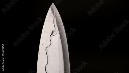 Water drop on sharp knife isolated on dark background. water splashing on knife.