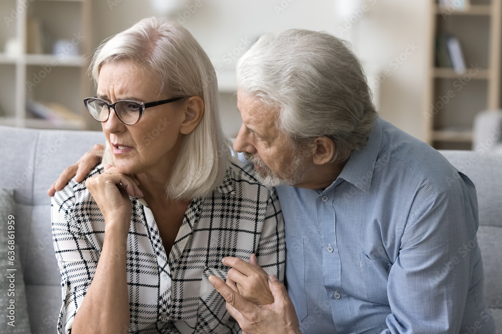 Worried old husband hugging anxious wife with mental disorder, panic attack, consoling depressed upset woman, touching shoulders, giving help, support. Couple getting problems, bad news