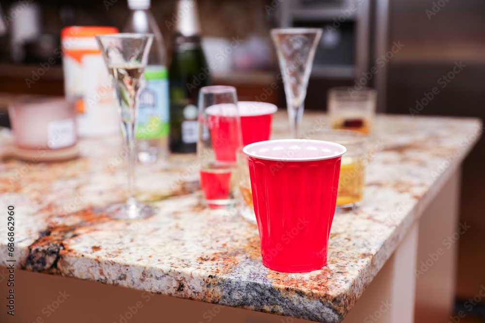 Plastic cups at a lively party embody celebratory spirit, casual socializing, and youthful exuberance, symbolizing carefree moments and camaraderie