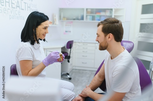 Man having a visit at the dentist's. Handsome patient sitting on chair at dentist office in dental clinic.