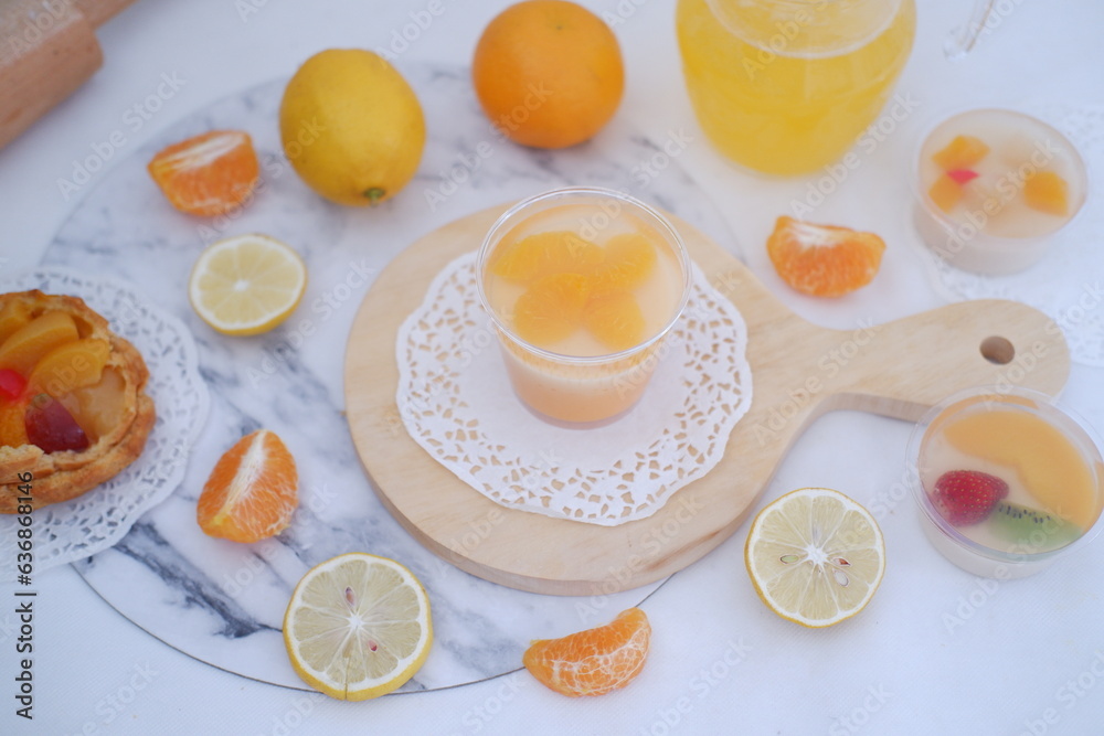 Fresh orange juice in glass and fresh citrus fruits on white background.