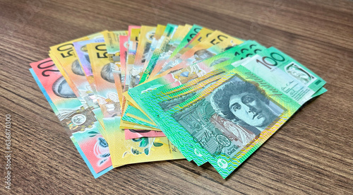 many notes of australian currency on wooden surface background photo