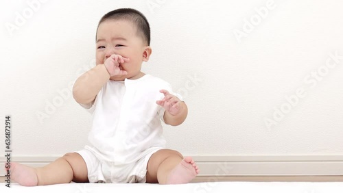 絨毯に座って泣く赤ちゃん（男の子、日本人、生後8か月）