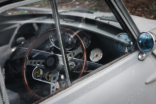 Closeup of old vintage retro car with classic wood wheel steering. Antique automotive vehicle and transportation collection concept. © TimmyTimTim