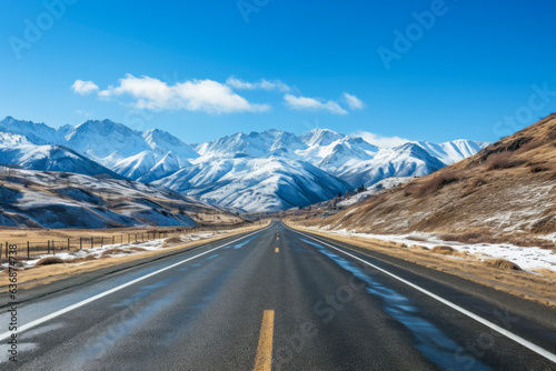 Straight very long asphalt road in a Beautiful winter mountain landscape with a blue sky in the background. good business concept for life and success. © cwa