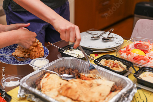 Hands and utensils gather around, embracing the communal spirit of a potluck dinner. Symbolizing unity, sharing, and indulgence as they enjoy a variety of desserts