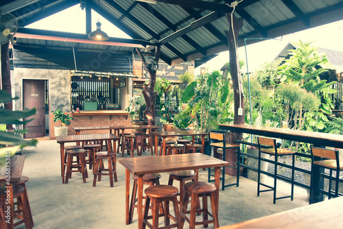 The wooden tables in front of the coffee shop and iron tables have soft cushions.