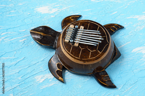 Kalimba turtle on a blue background. Traditional instrument from Africa in close-up. photo