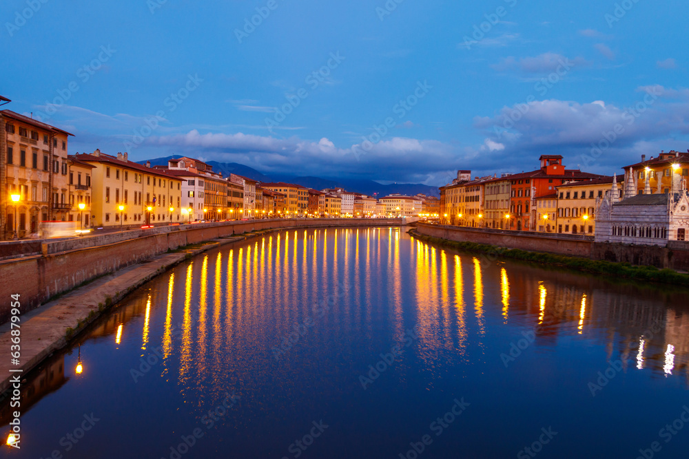 Panoramic view of the old town of Pisa and the Arno river at twilight, Italy. Night cityscape