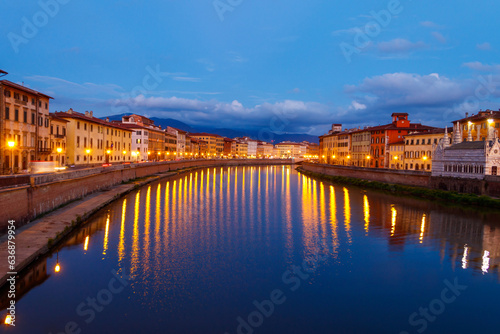Panoramic view of the old town of Pisa and the Arno river at twilight, Italy. Night cityscape © olyasolodenko
